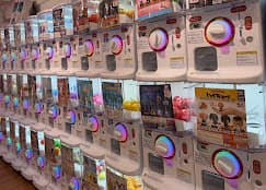 Rows of white capsule-toy machines glowing inside Gacha Zakka
